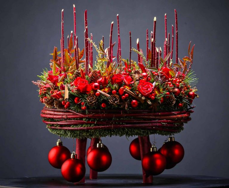 Christmas workshops are the most successful ones. Wreaths are traditional at this time of the year. Here it is special as the wreath has legs and not touching the table. Decorated with Christmas balls hanging under it. Typical christmas decoration on the top.