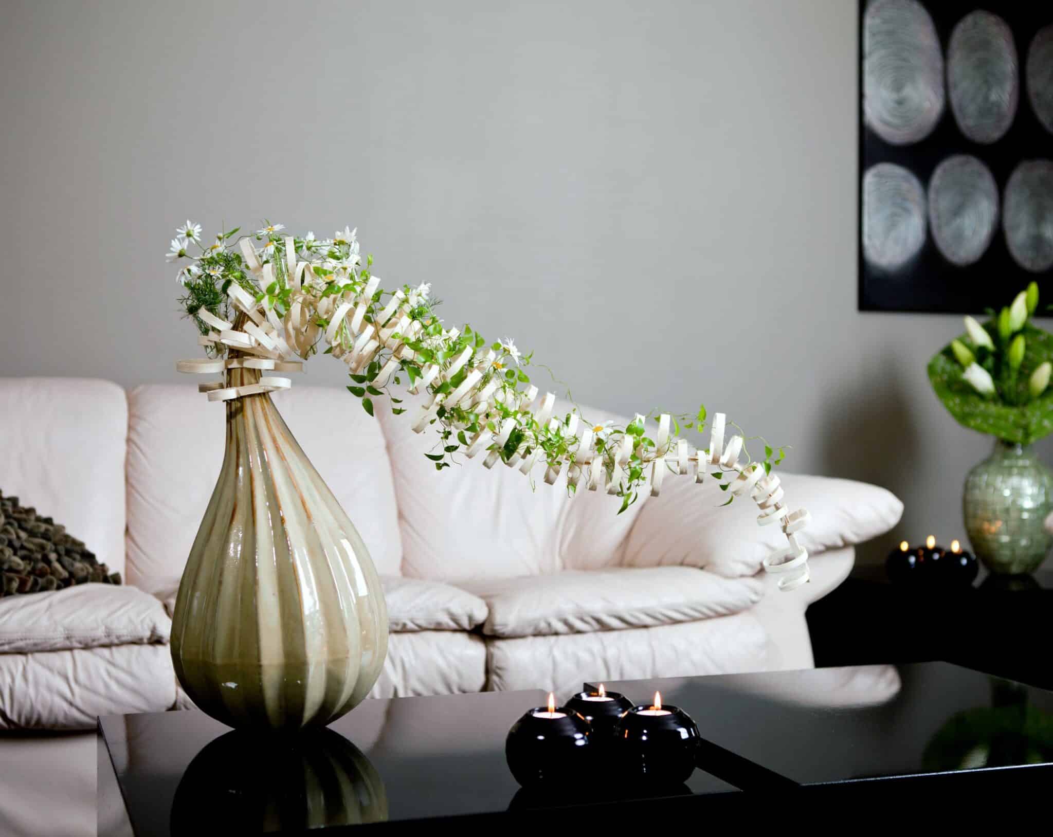 Decorative composition on a styled vase. Rings of rotan and white flowers